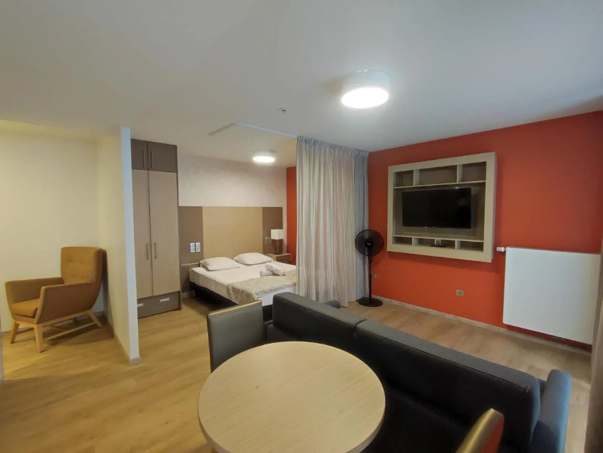Sleeping area with two beds, sofa and round table, TV recessed into the wall, Appart-One aparthotel, Fréjus