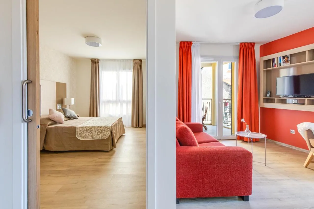 Two-space unit: bedroom with double bed on one side, living room with red sofa and TV on the other, Appart-One aparthotel, Fréjus