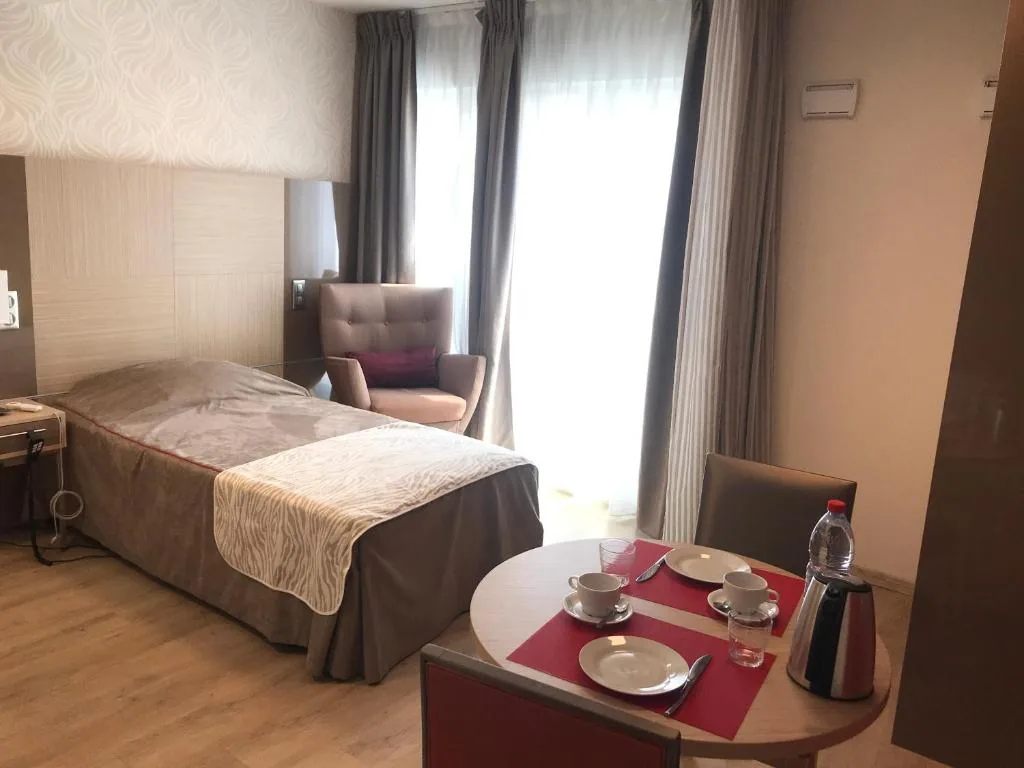 Furnished studio: single bed, armchair and laid dining table by the window, Appart-One aparthotel, Montreuil